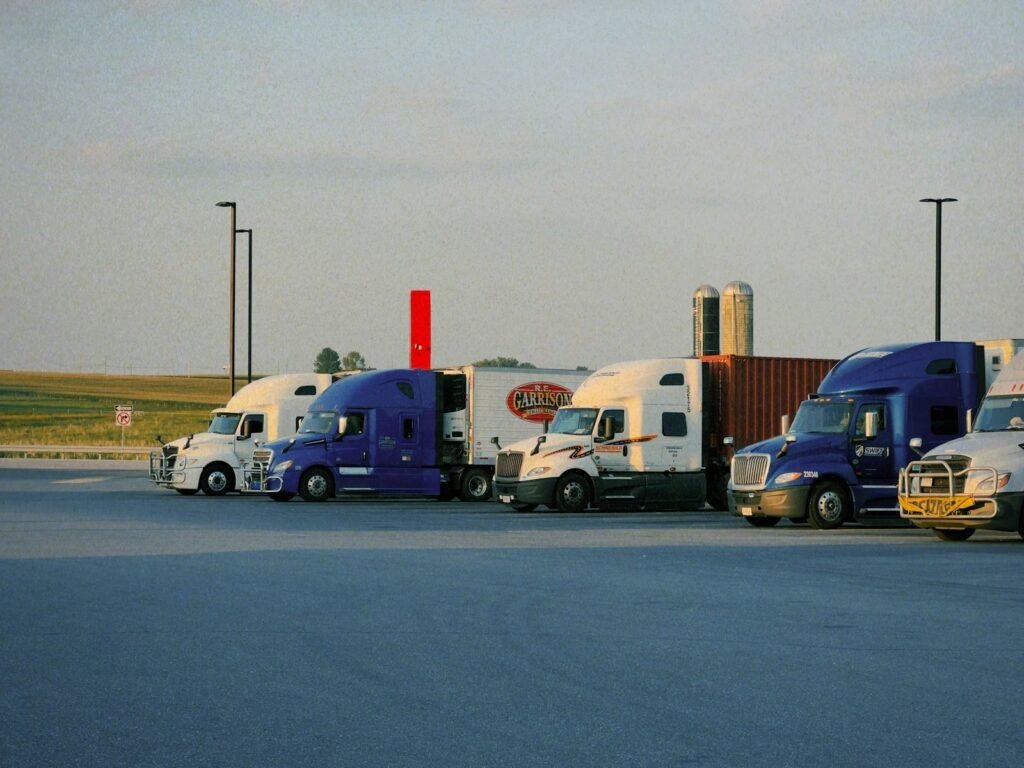 A row of semi trucks parked in a parking lot